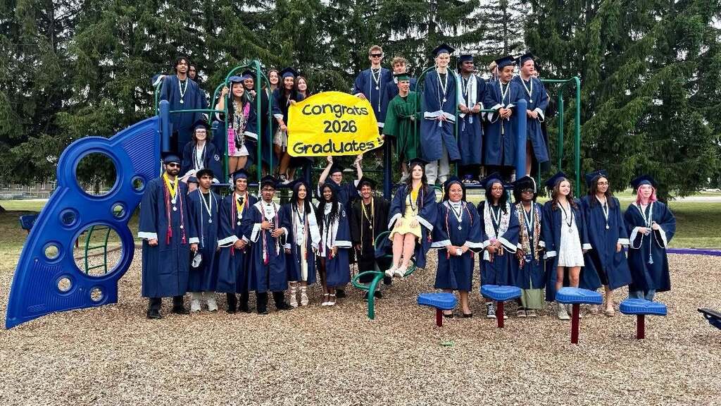 A group of high school seniors in their caps and gowns on a playground