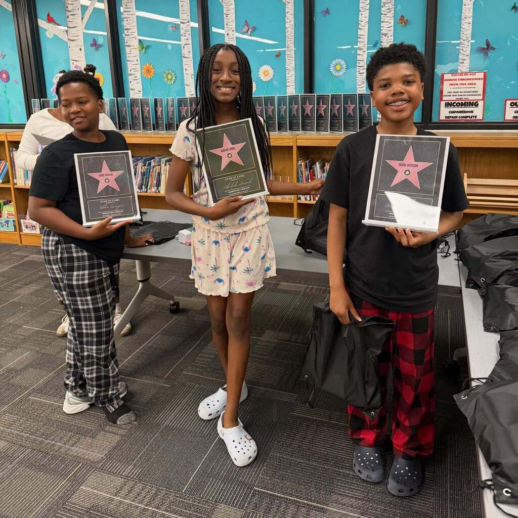 Three students pose with star awards