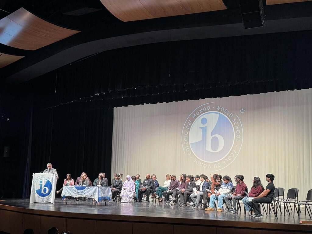 Photo of a stage where all  of the graduates, speakers, and teachers on the stage.