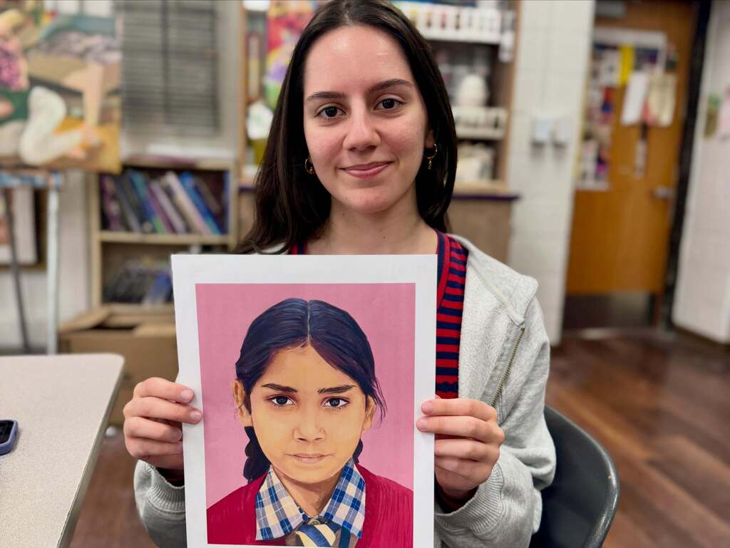 FHS student holding up her artwork.