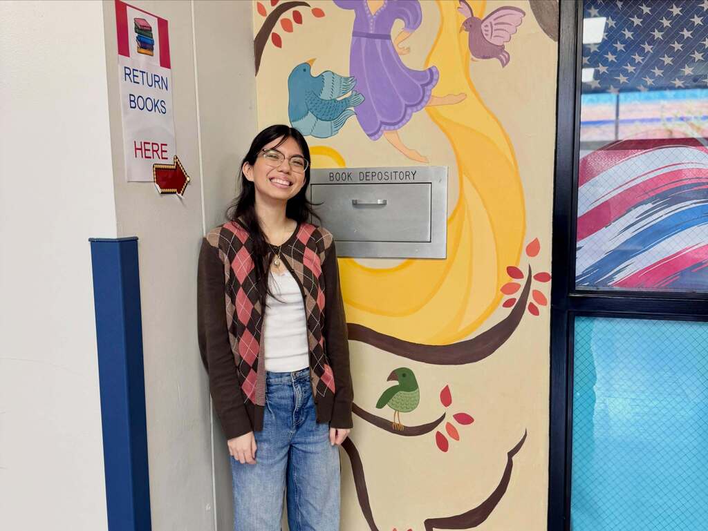 FHS student standing in front of her mural done for NAHS.