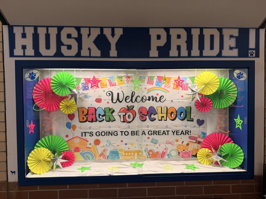 Colorful bulletin board with 'Welcome Back to School' message and bright paper fans, celebrating a new school year at Husky Pride.
