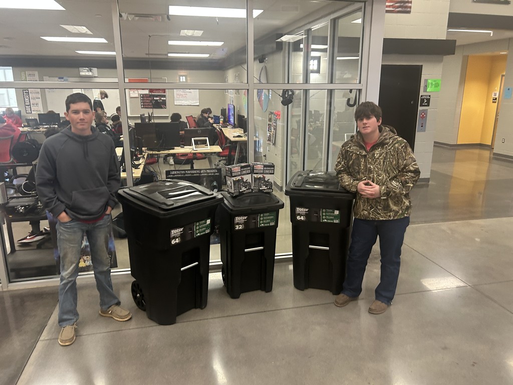 students posing with trash cans
