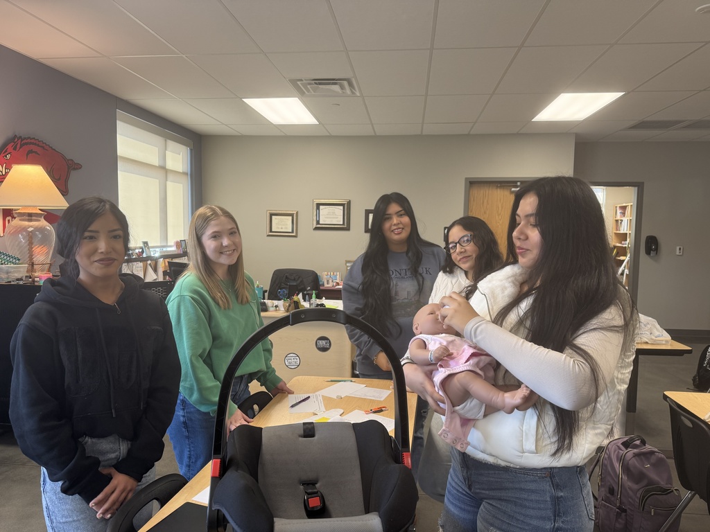 students posing with baby doll