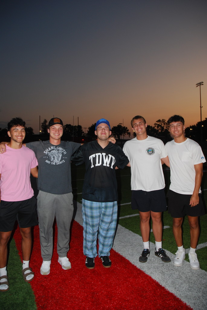 students posing on football field