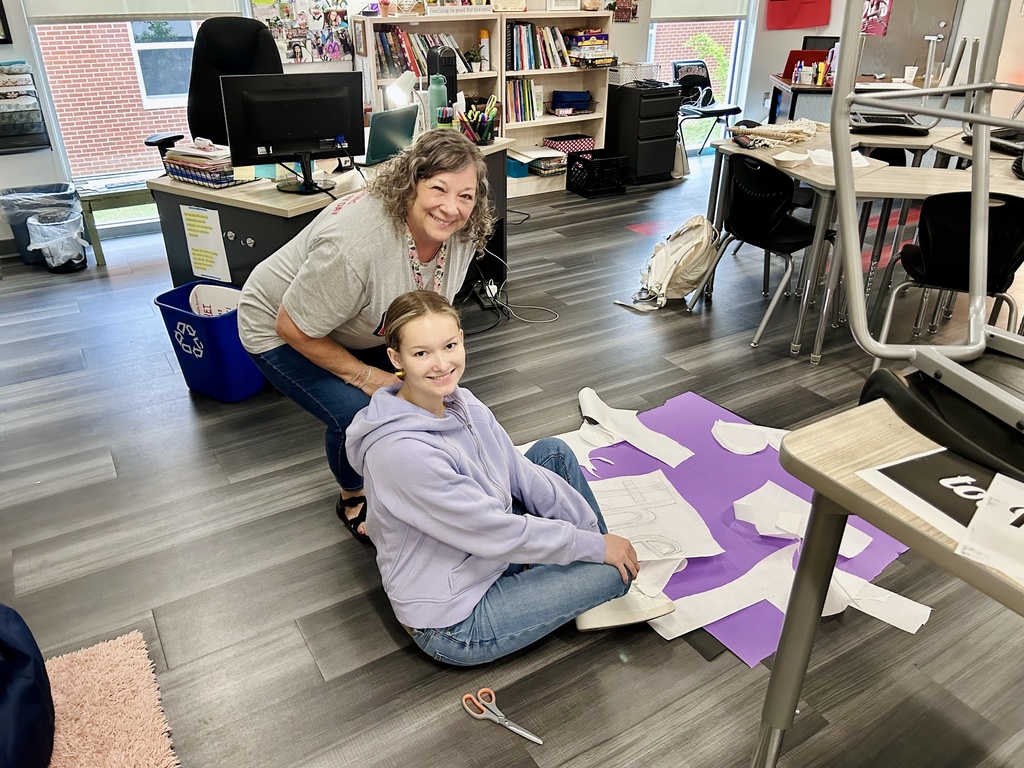 Teacher and intern on floor smiling for camera