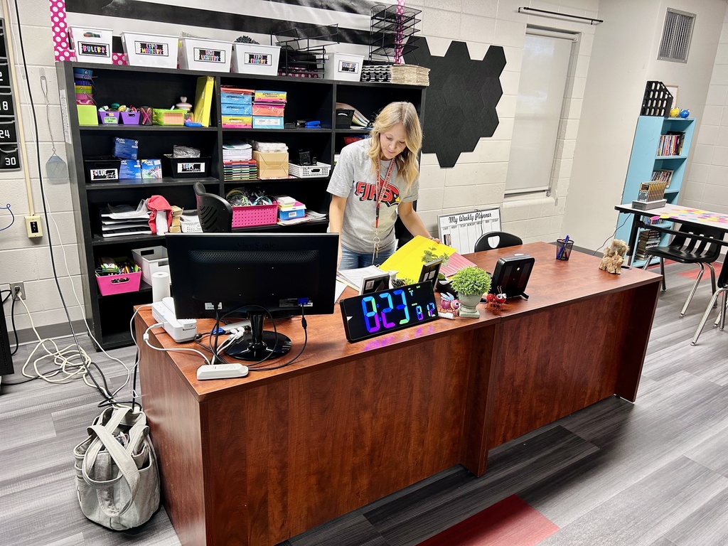 Teacher standing behind desk