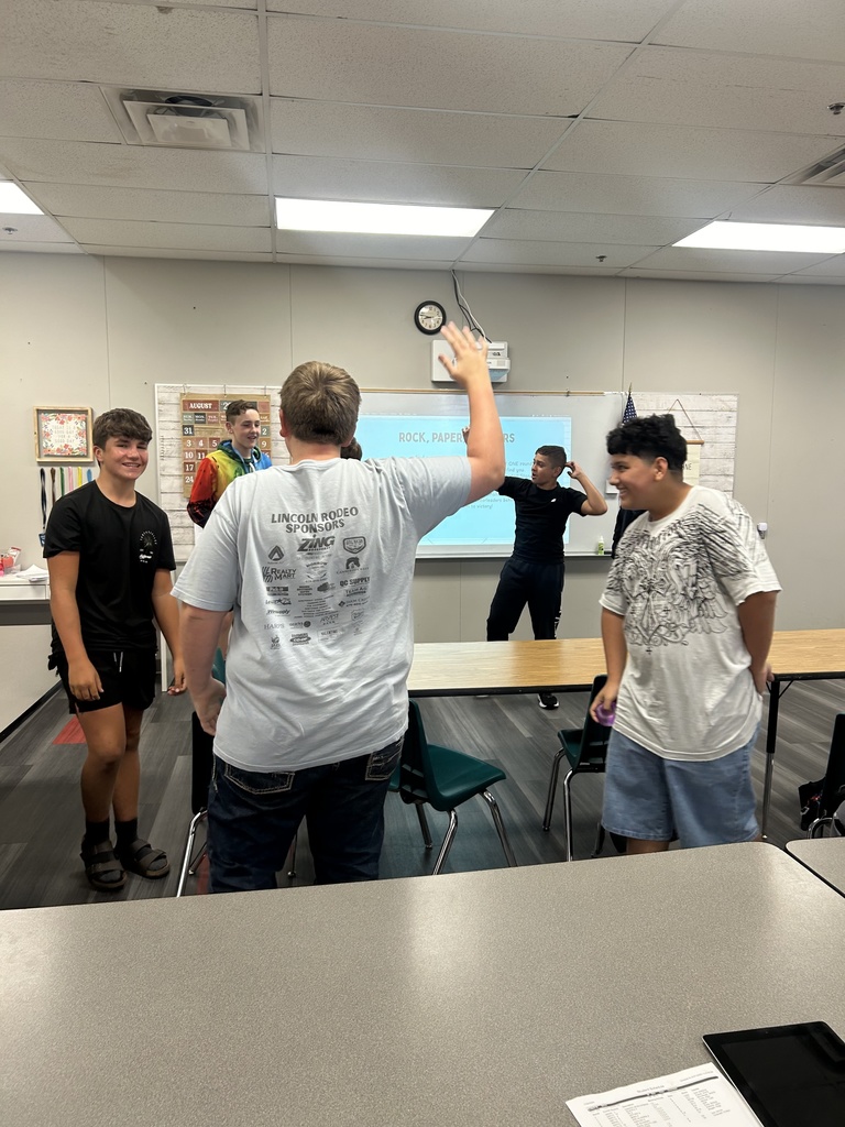 Students standing in class, playing a game