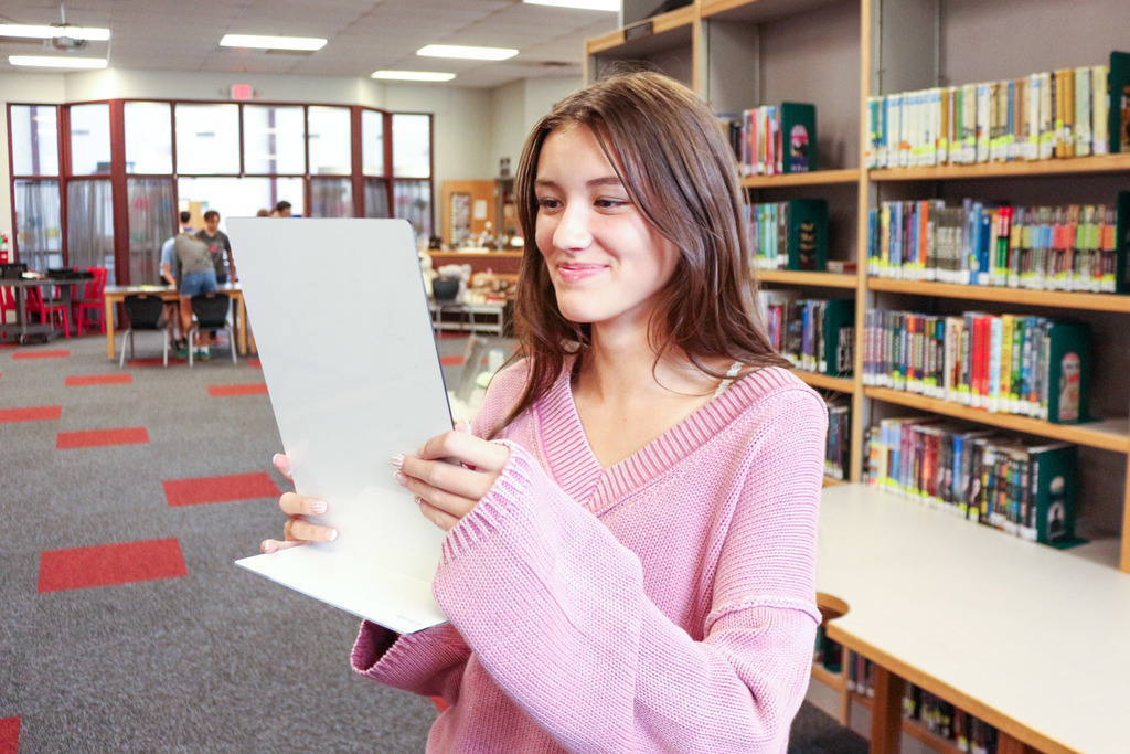 Student checking herself in a mirror before photo