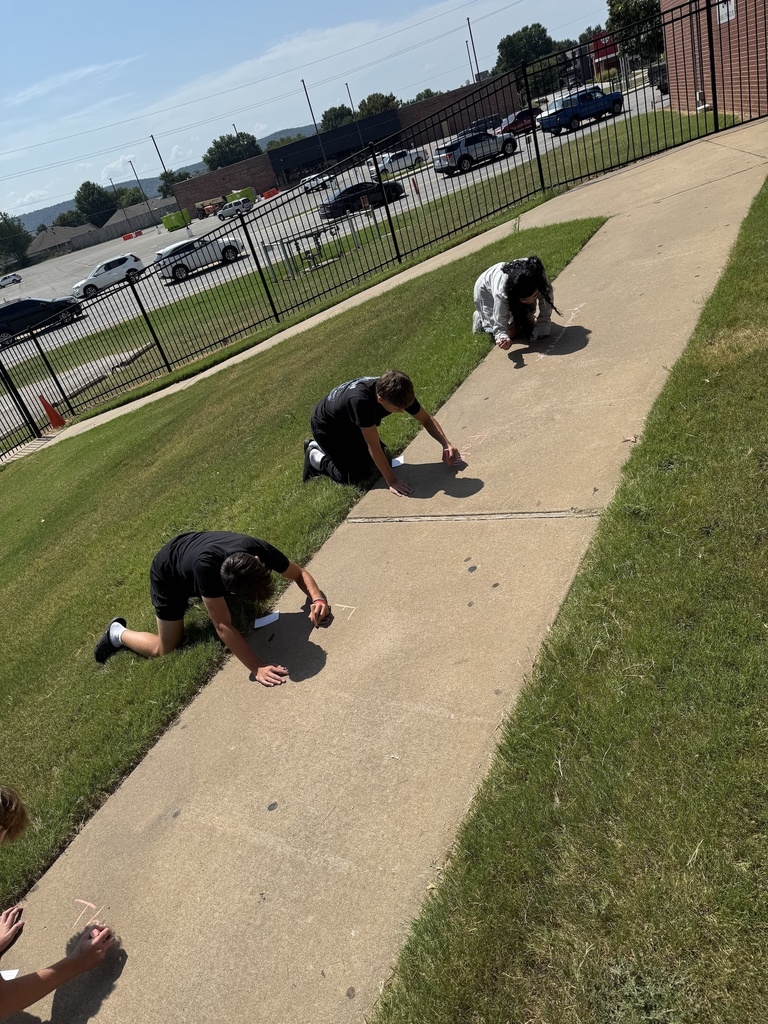 Students writing on sidewalk in chalk