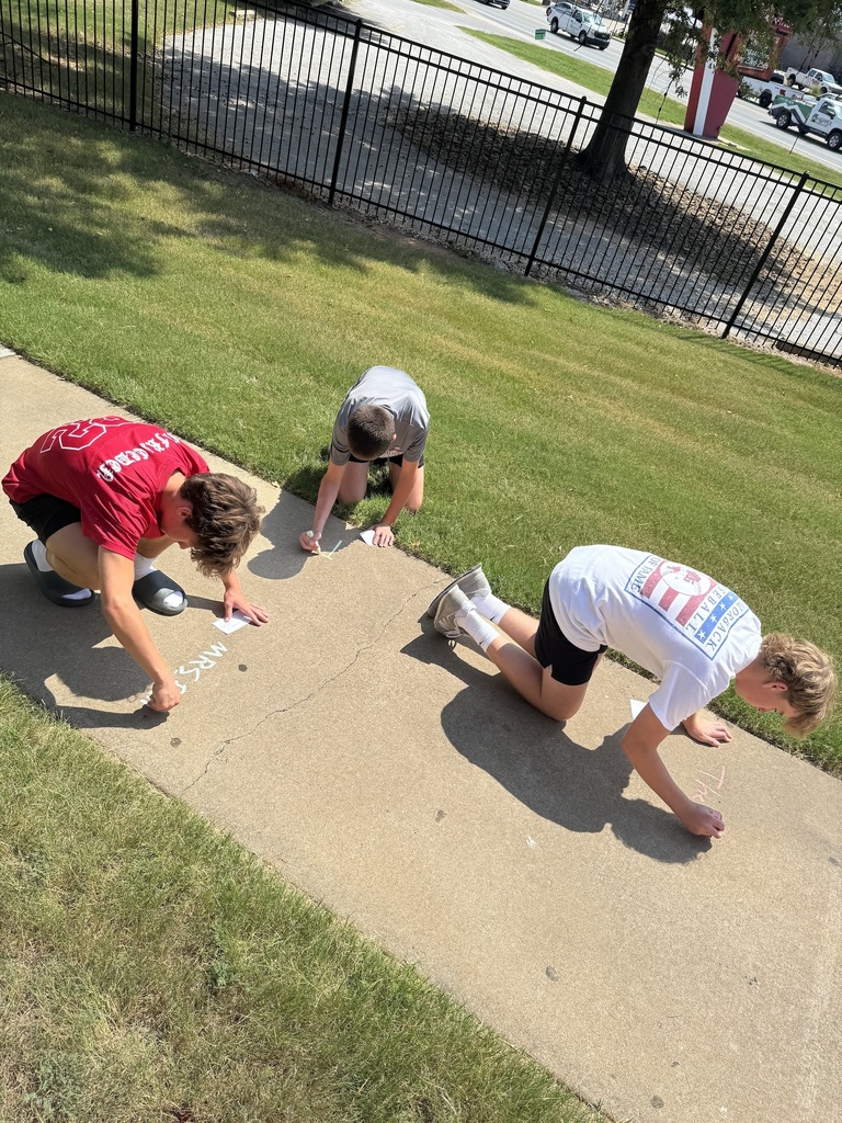 Students writing on sidewalk in chalk
