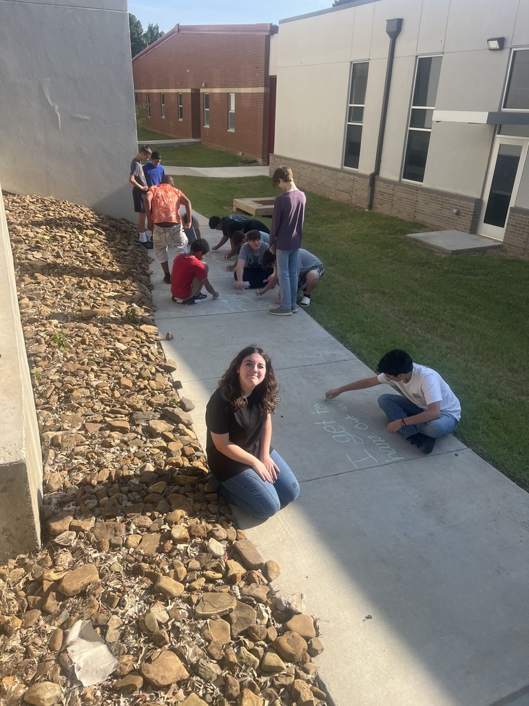 Students writing on sidewalk in chalk
