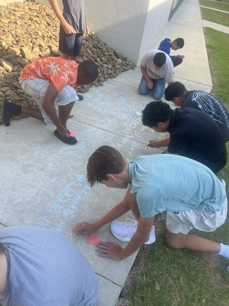 Students writing on sidewalk in chalk