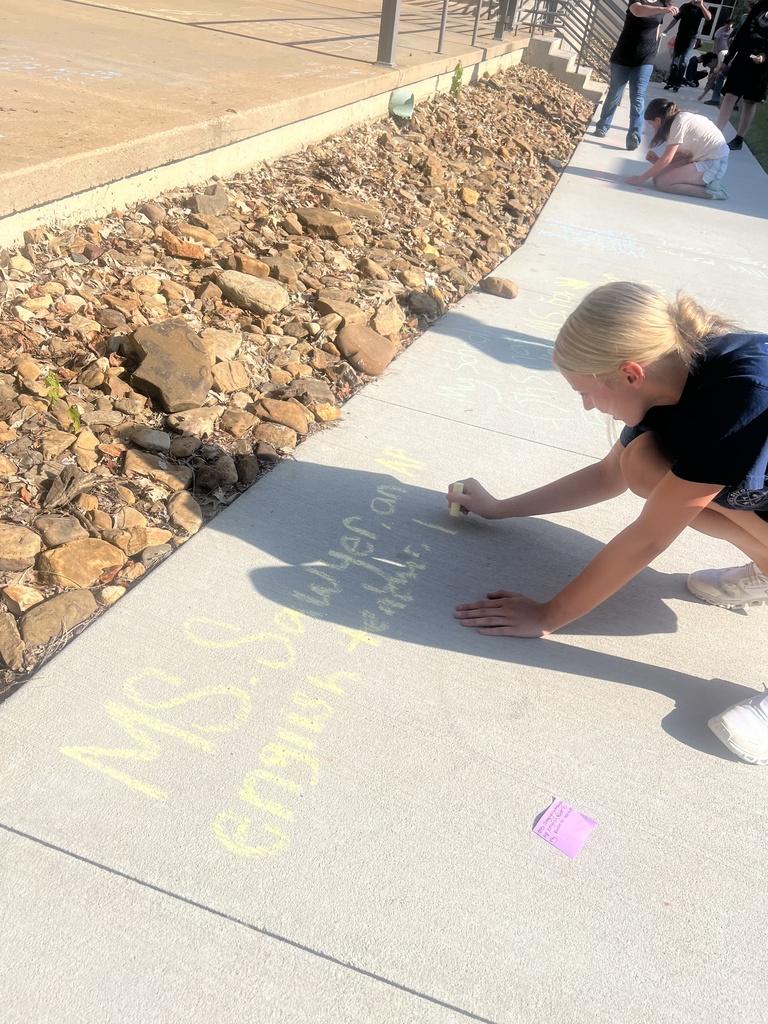 Students writing on sidewalk in chalk
