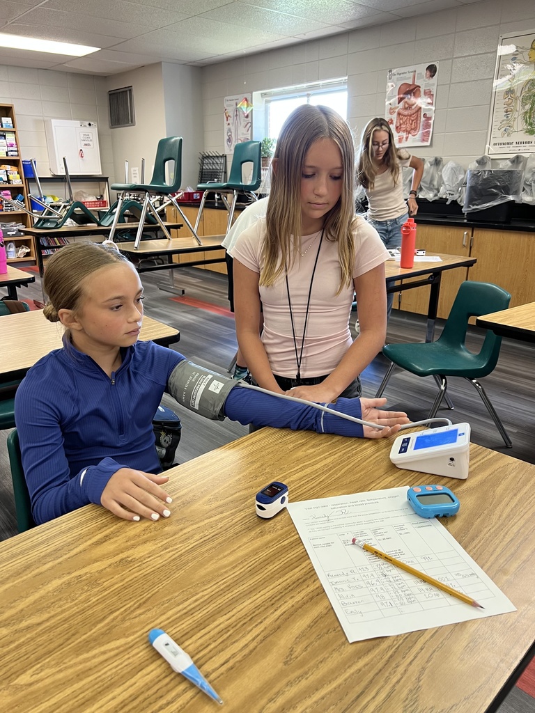 Student getting her blood pressure reading from another student