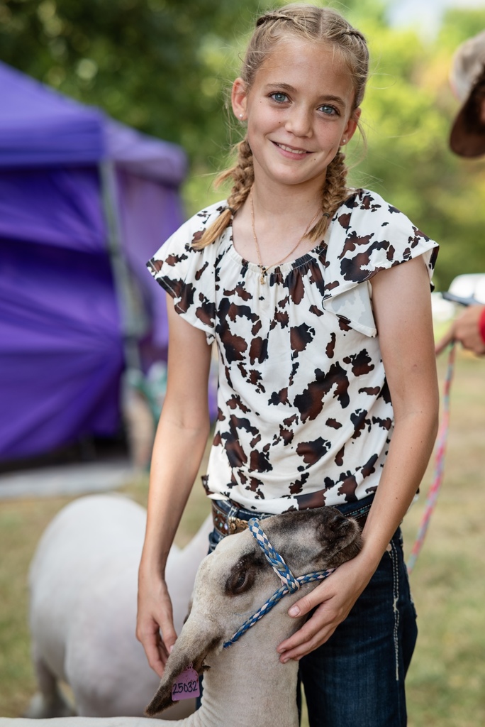 Student poses with her lamb at fair