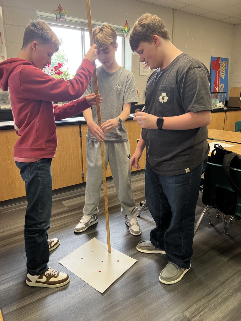 Students measuring drops with a yard stick