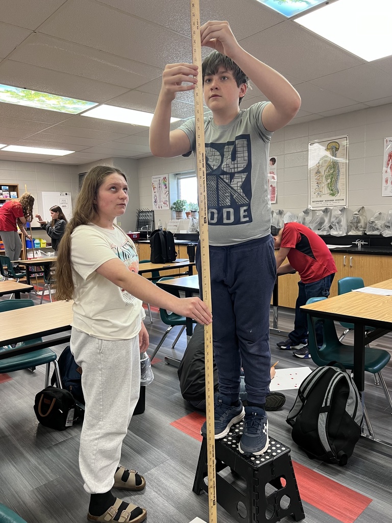 Students measuring drops with a yard stick