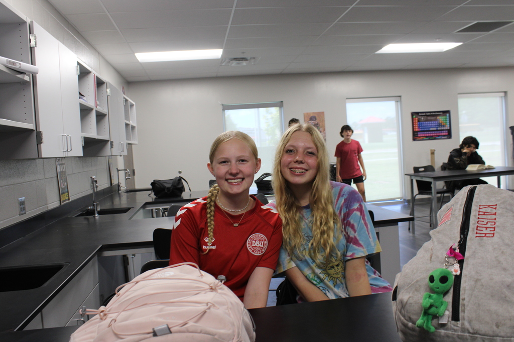 picture of students smiling and sitting together.