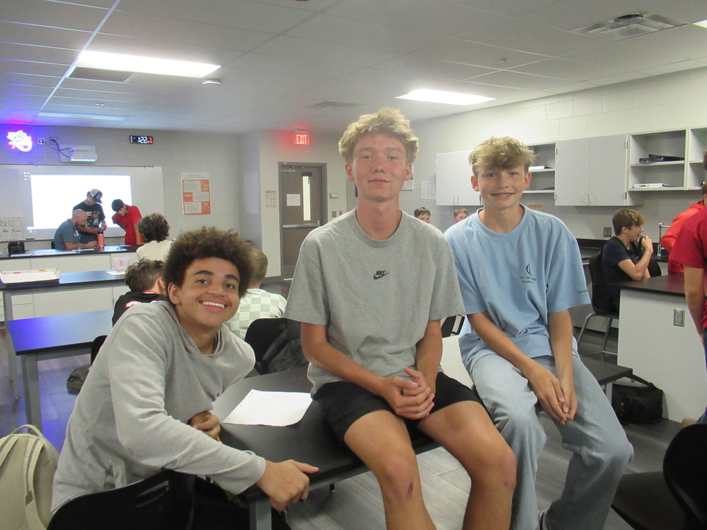Three boys sitting in class together