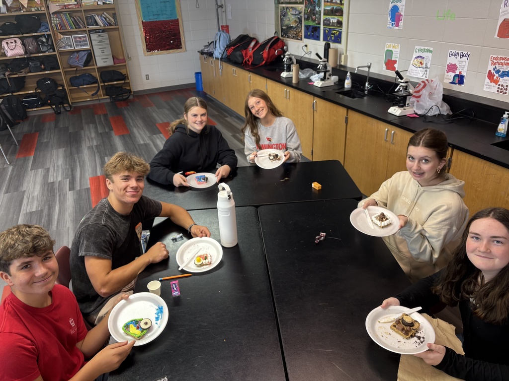 Students smiling while posing with their "cookie cells"