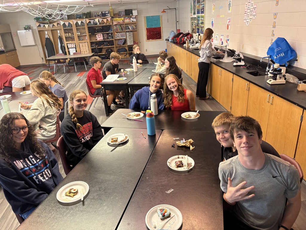 Students smiling while posing with their "cookie cells"