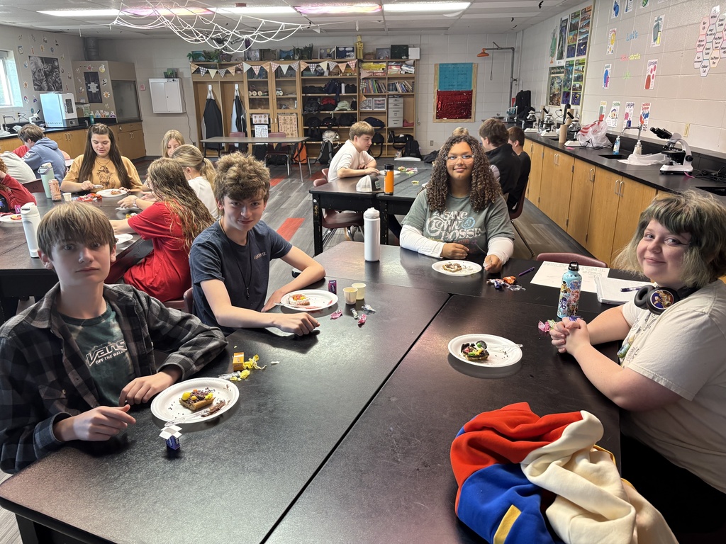 Students smiling while posing with their "cookie cells"