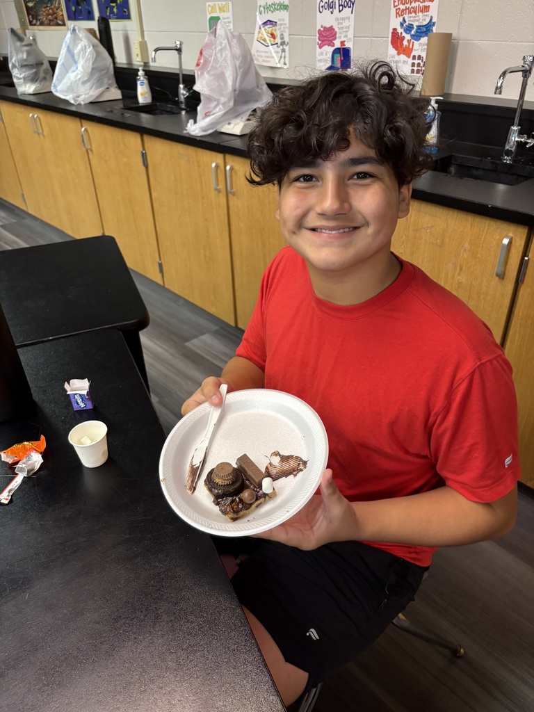 Student smiles with "cookie cell" he made.