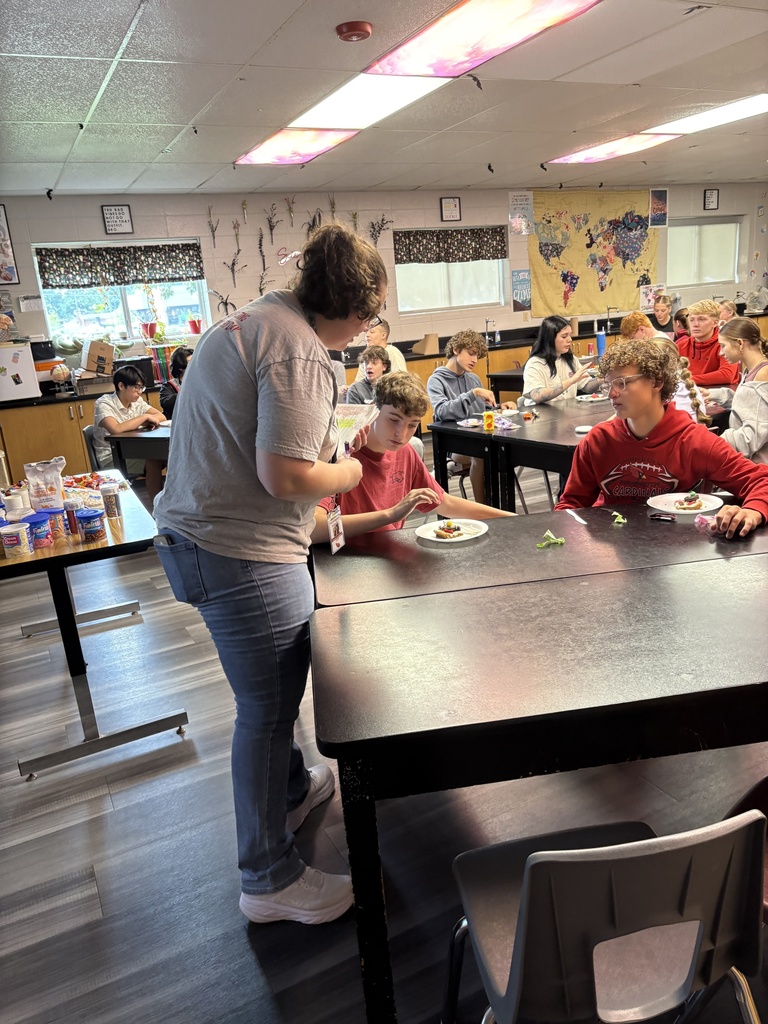 Teacher helping students at a table