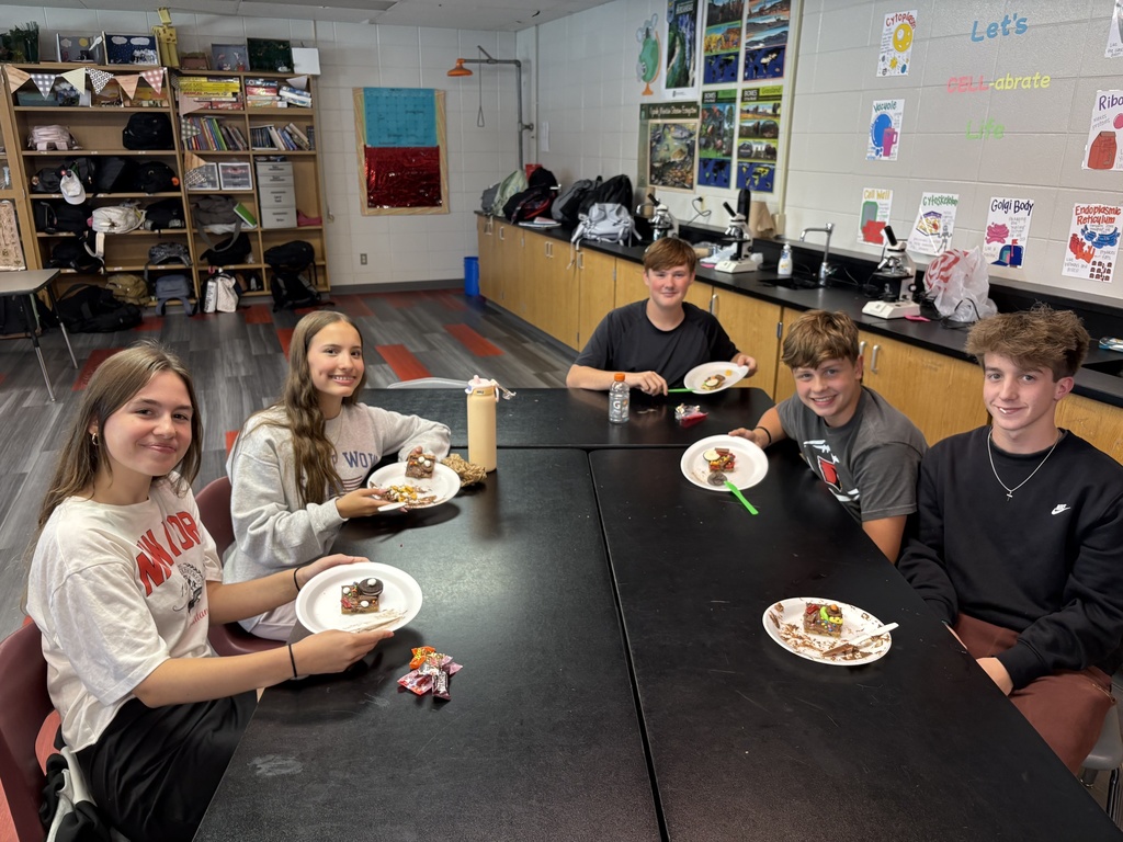 Students smiling while posing with their "cookie cells"