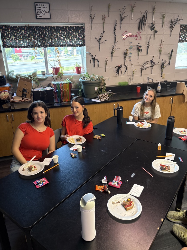 Students smiling while posing with their "cookie cells"