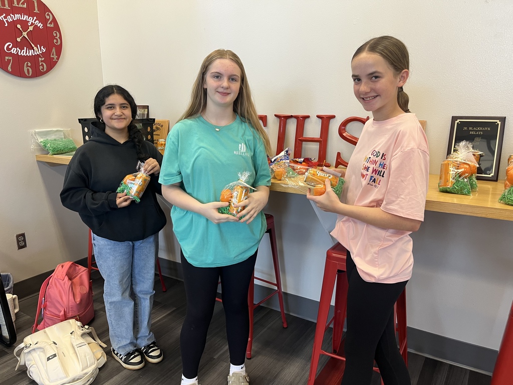 3 students holding goodie bags they made