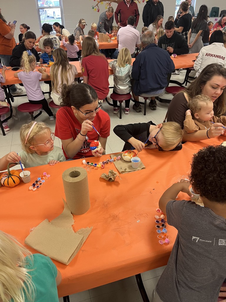FJHS Student helping pre-k student paint pumpkin