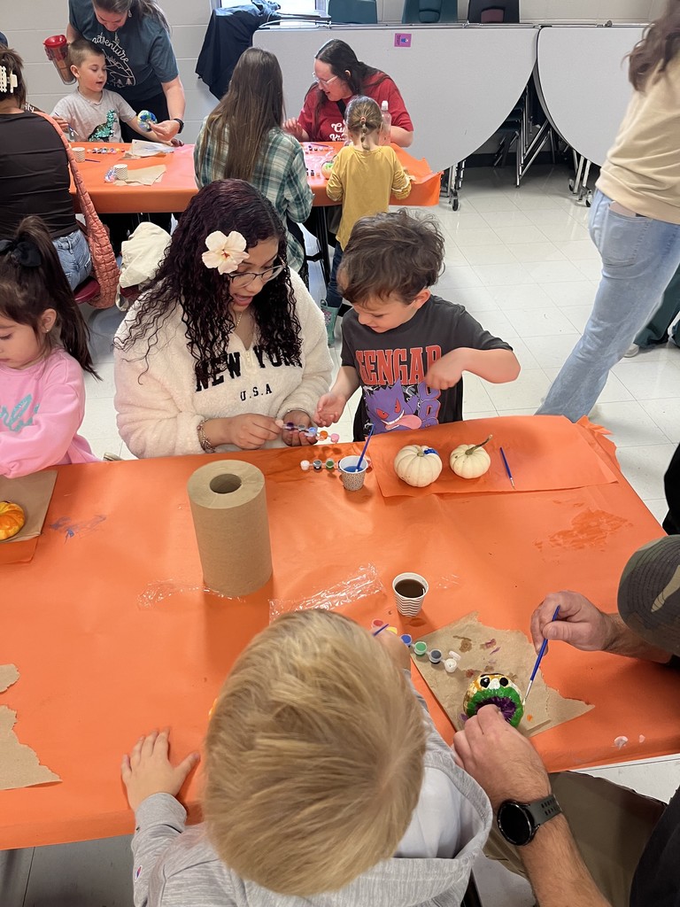 FJHS Student helping pre-k student paint pumpkin
