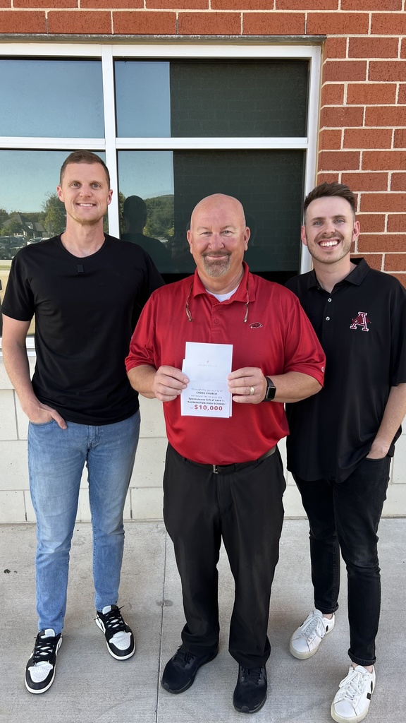 principal and pastors posing with certificate