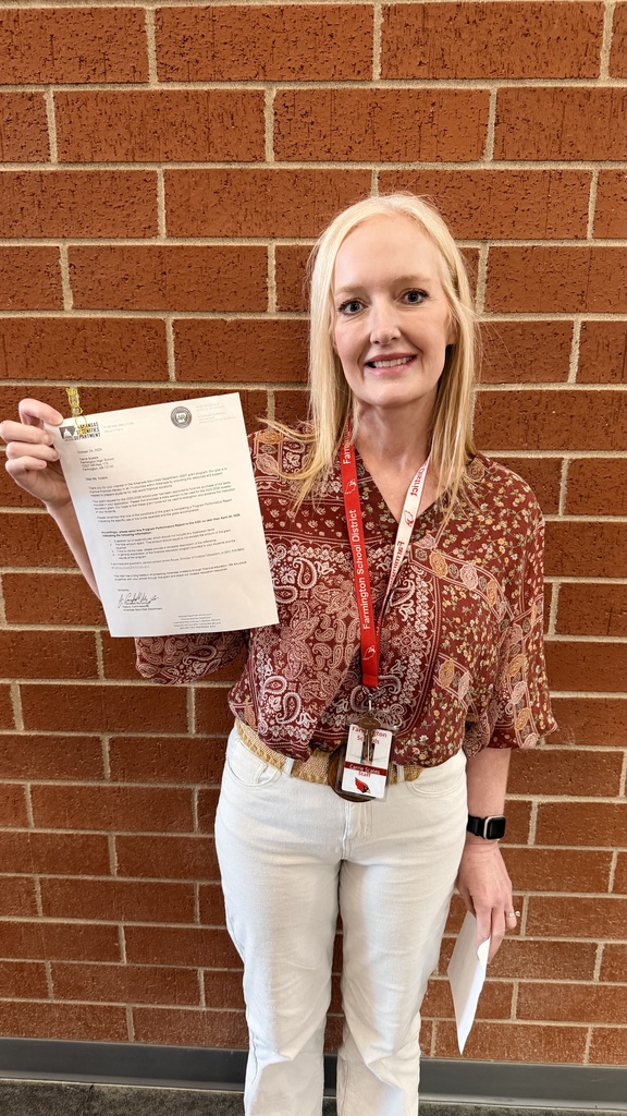 teacher posing with check