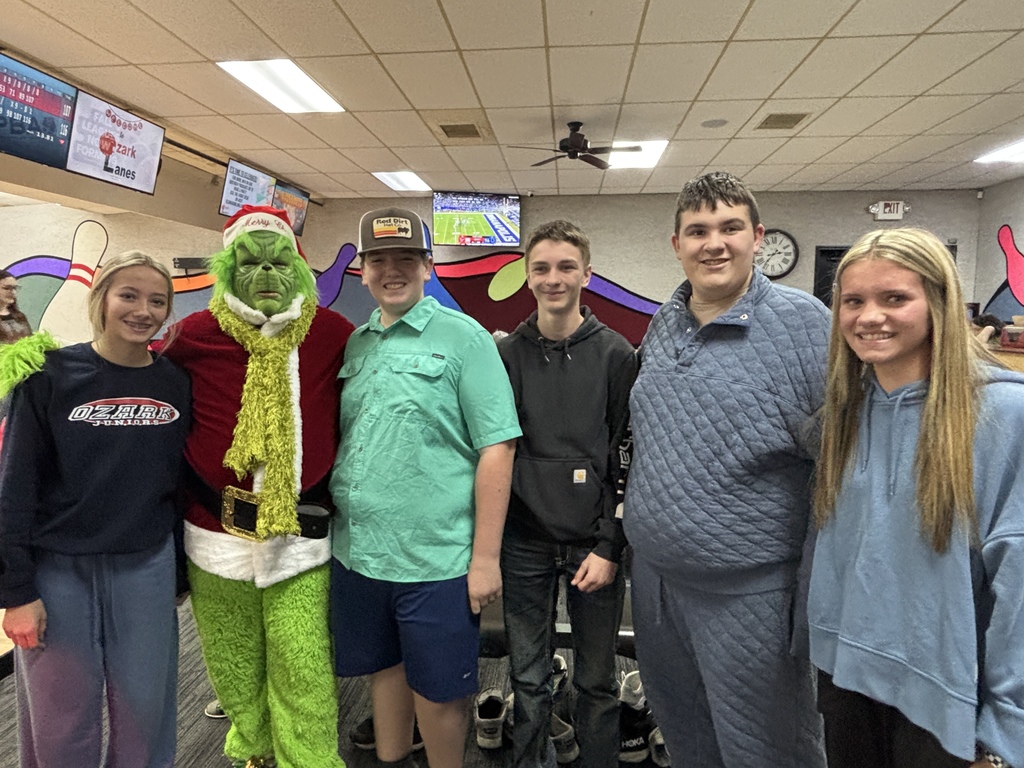 students posing with grinch