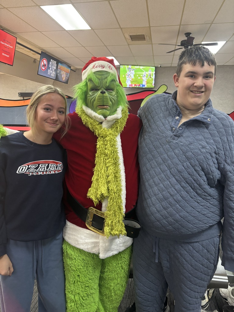 students posing with grinch