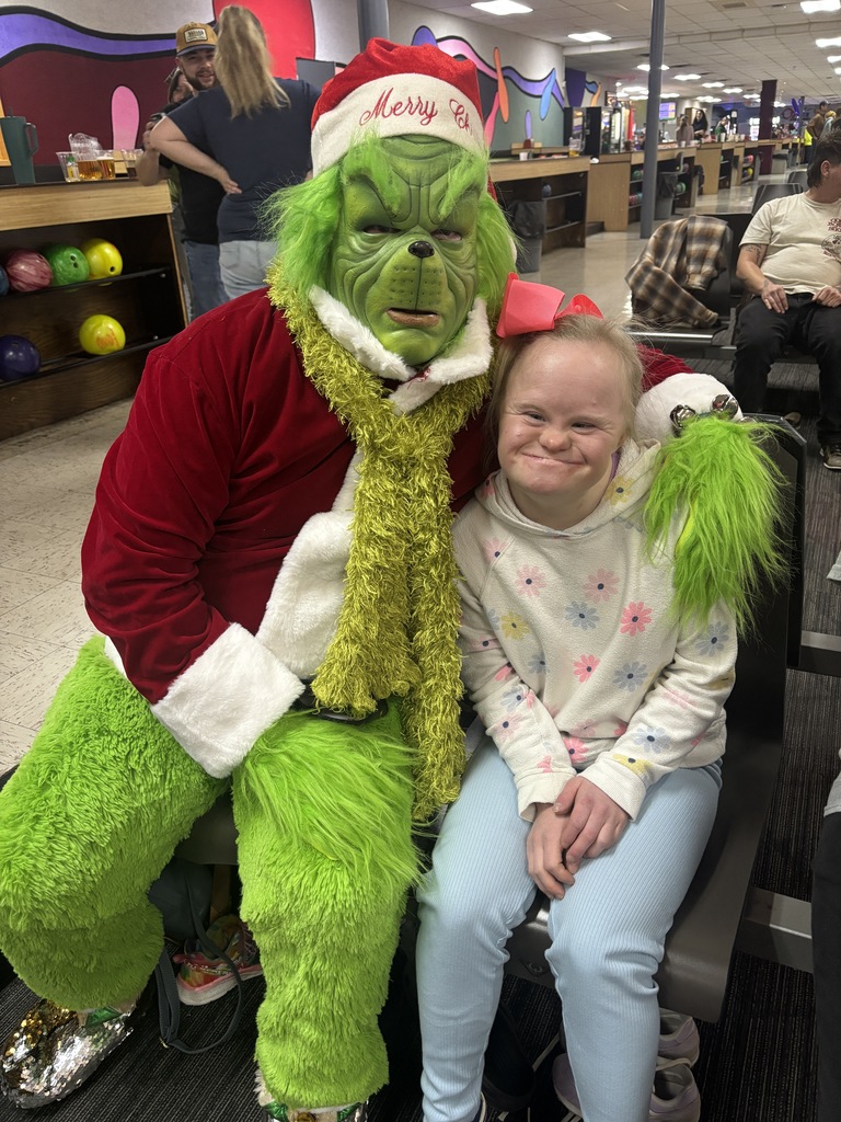 students posing with grinch