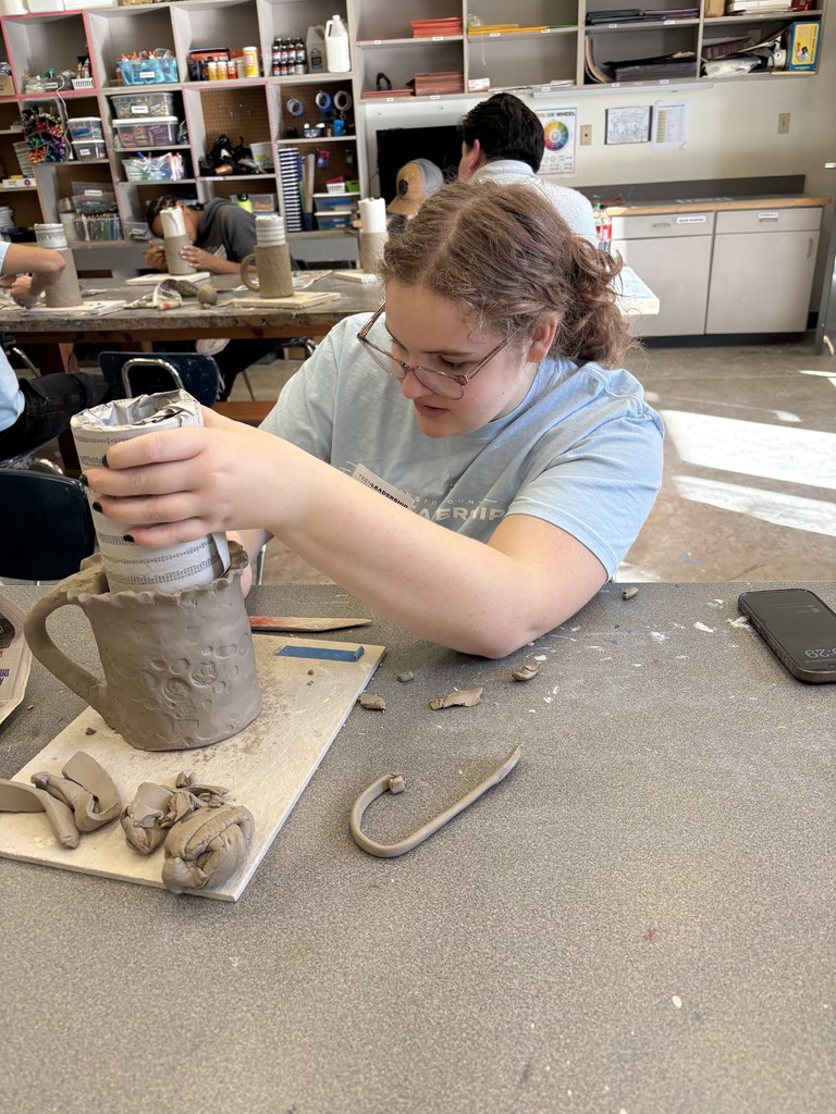 student making pottery