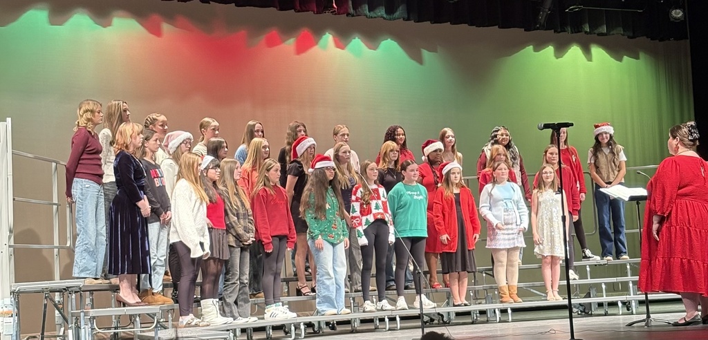 Members of the Jr. High choir on stage performing at a concert