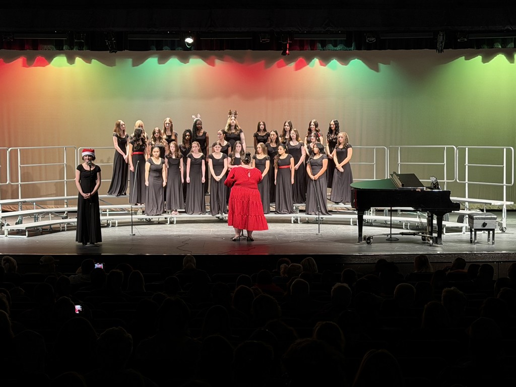 Members of the Jr. High choir on stage performing at a concert