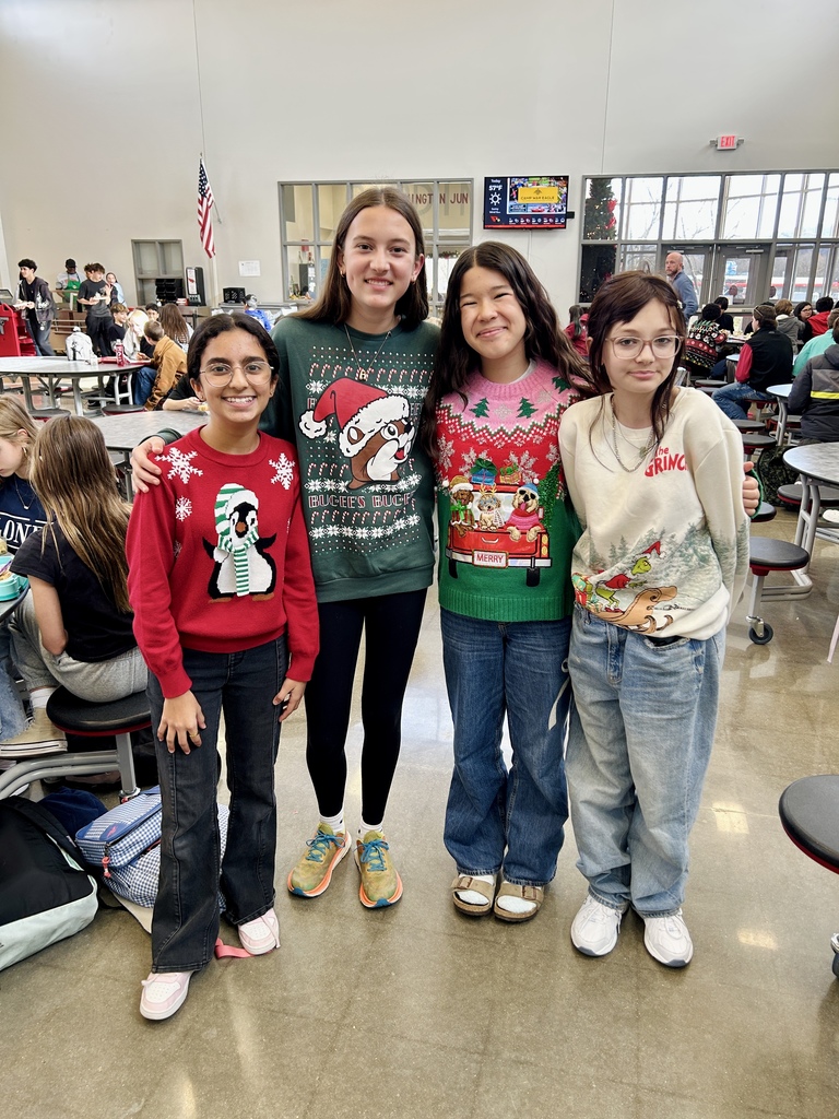 Students in commons area with ugly Christmas sweaters
