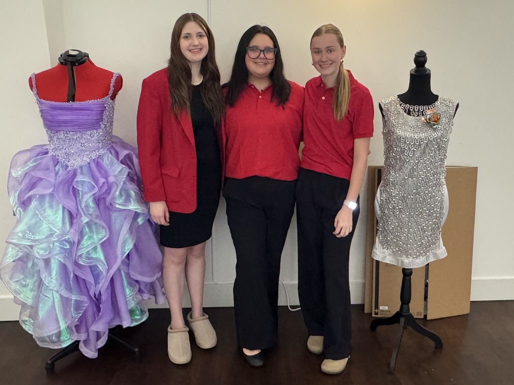 girls standing next to sewing projects