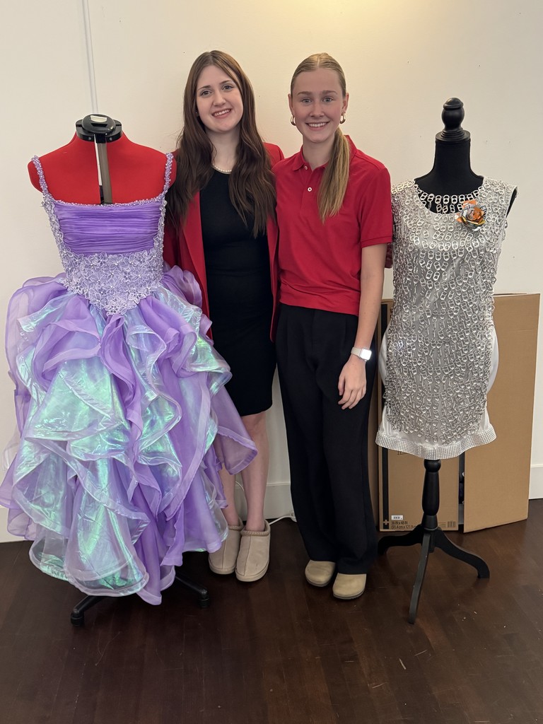 girls standing next to sewing projects