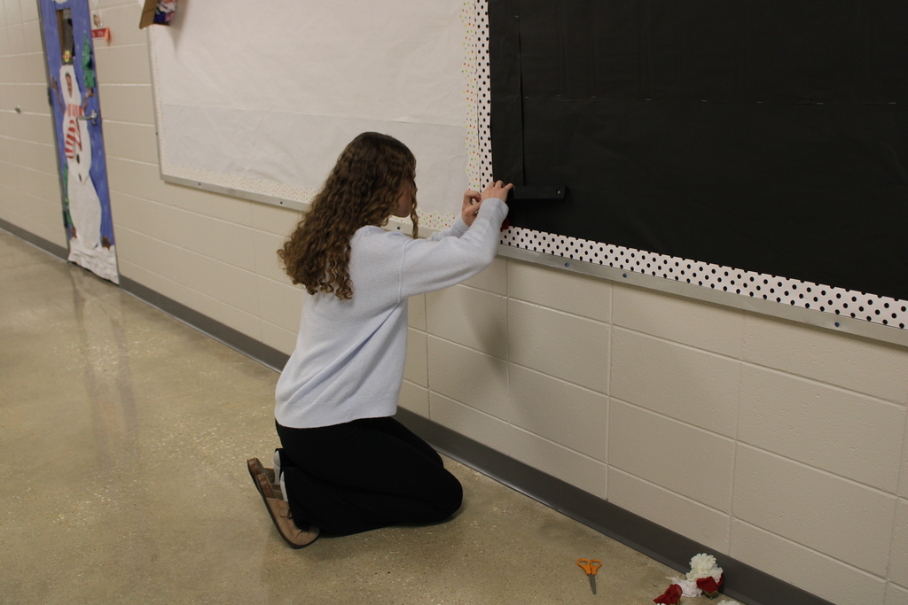 girl working on bulletin board 
