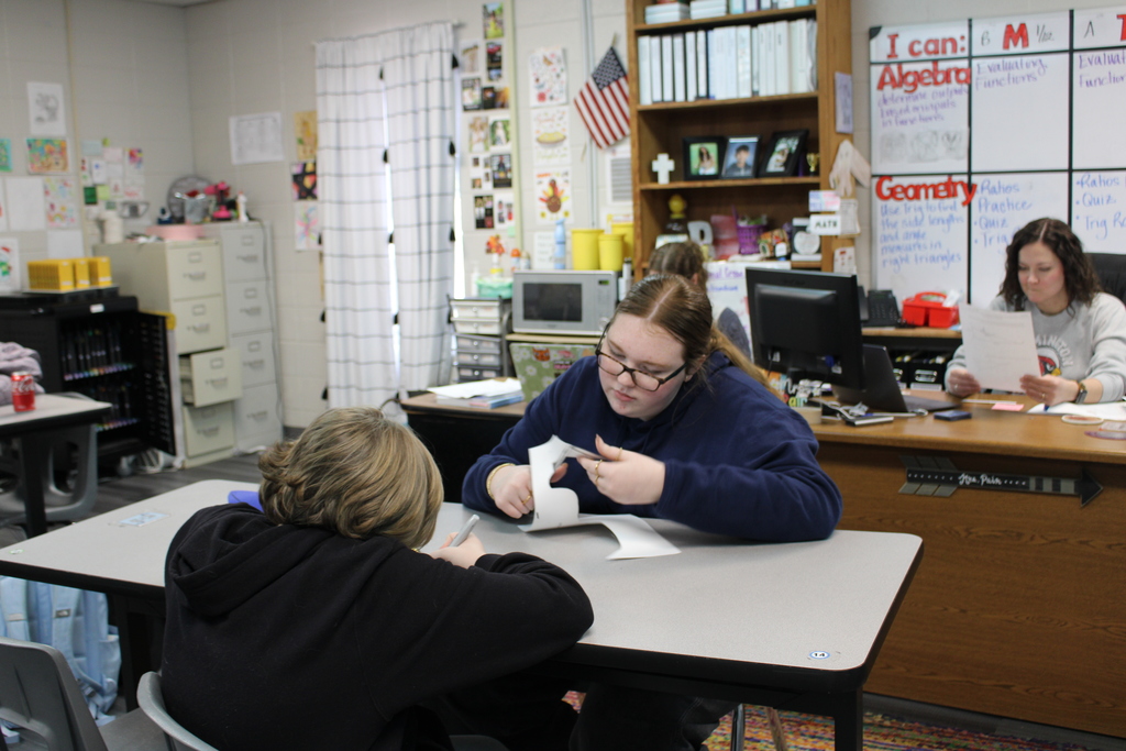 boy and girl cutting out paper for bulletin board