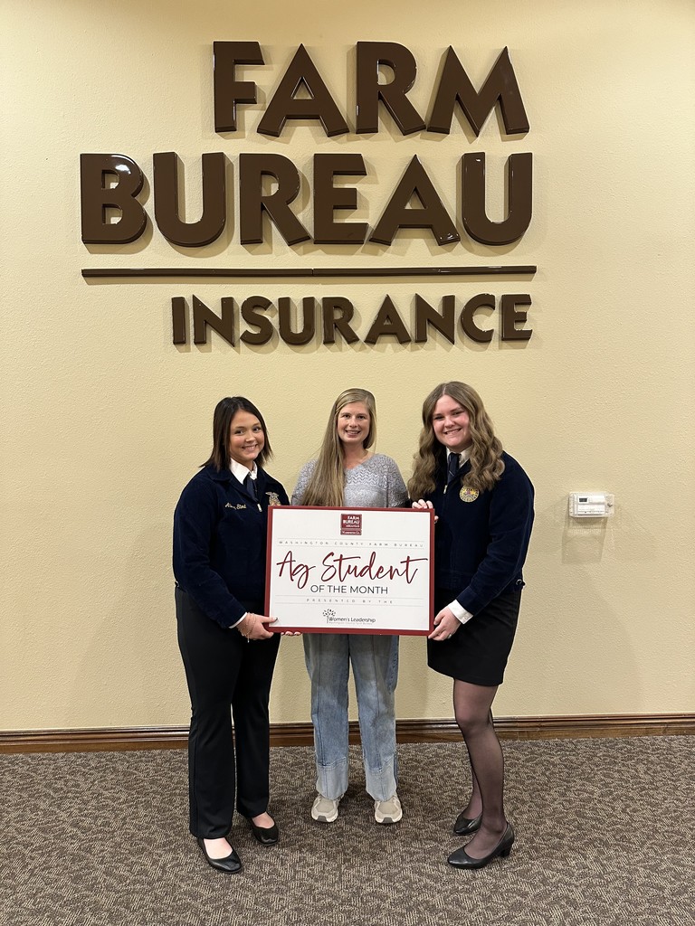 students and teacher posing with sign