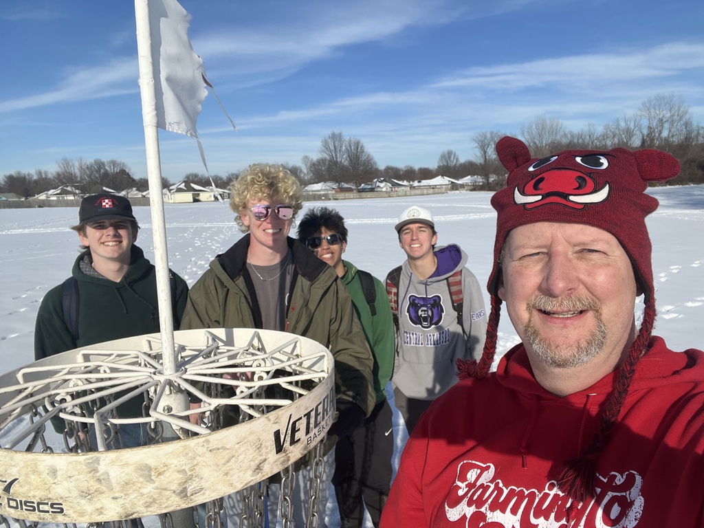 students posing by disc golf hole