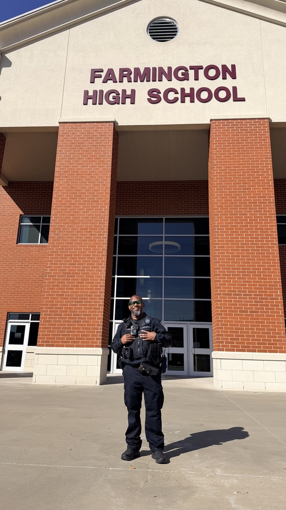 officer posing in front of building 